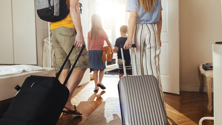 Family with suitcases leaving home