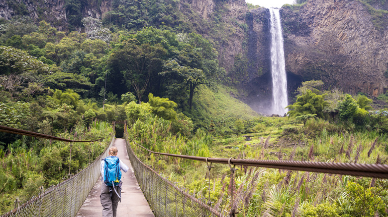 Hiker walking toward a waterfall