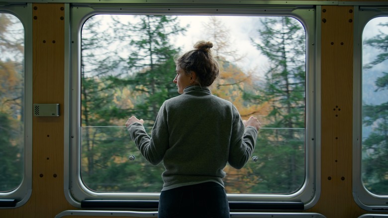 woman looks out train window