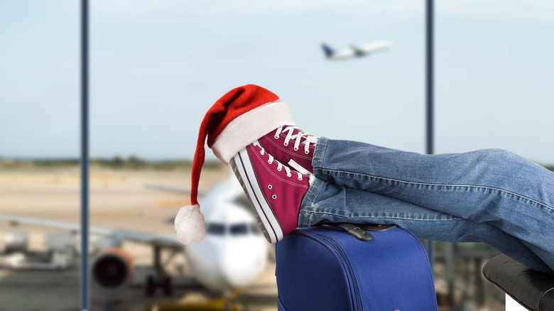Traveler resting feet on suitcase