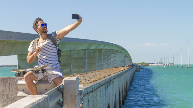 A man taking a selfie on a bridge
